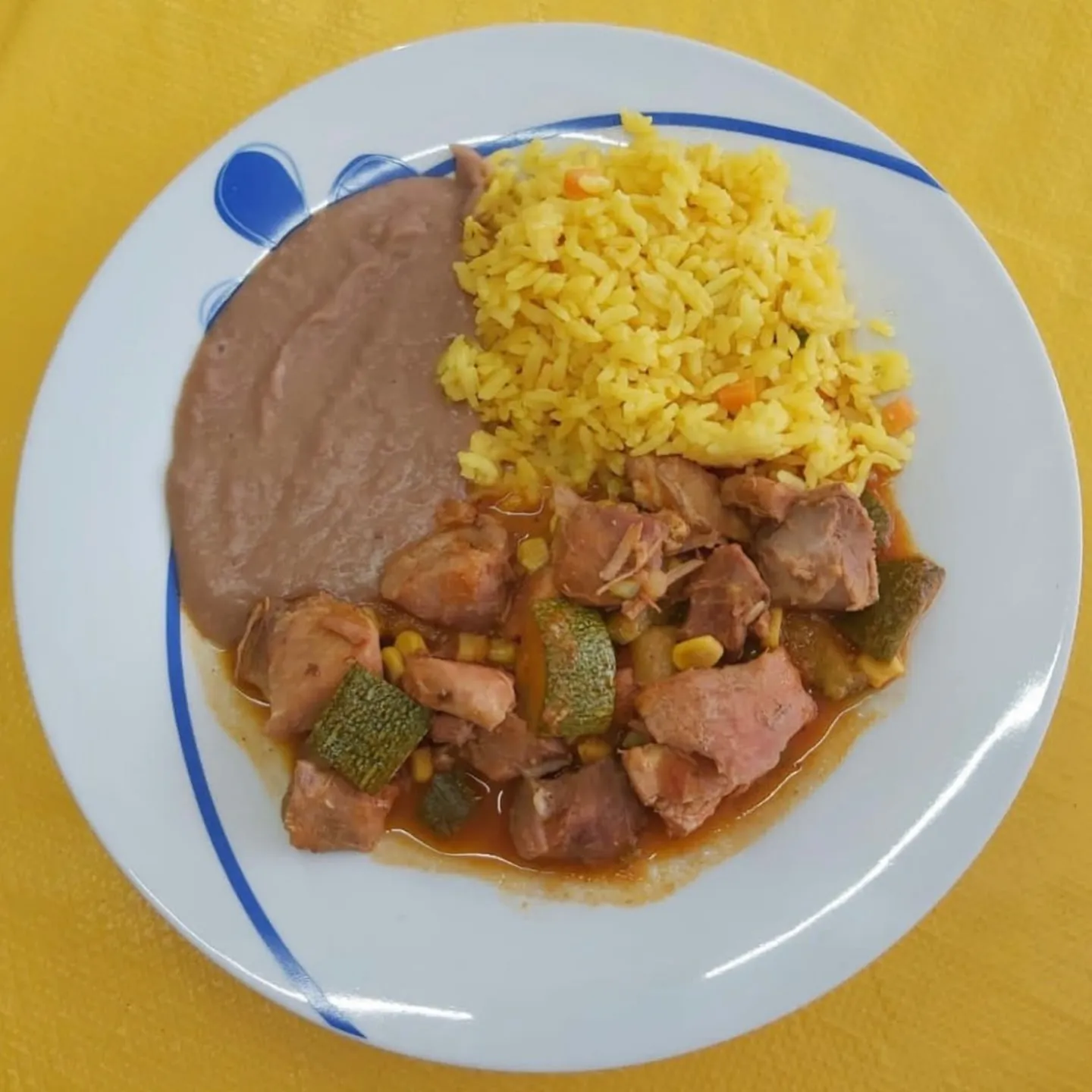 Carne de puerco con calabacitas y elote, frijoles y arroz amarillo