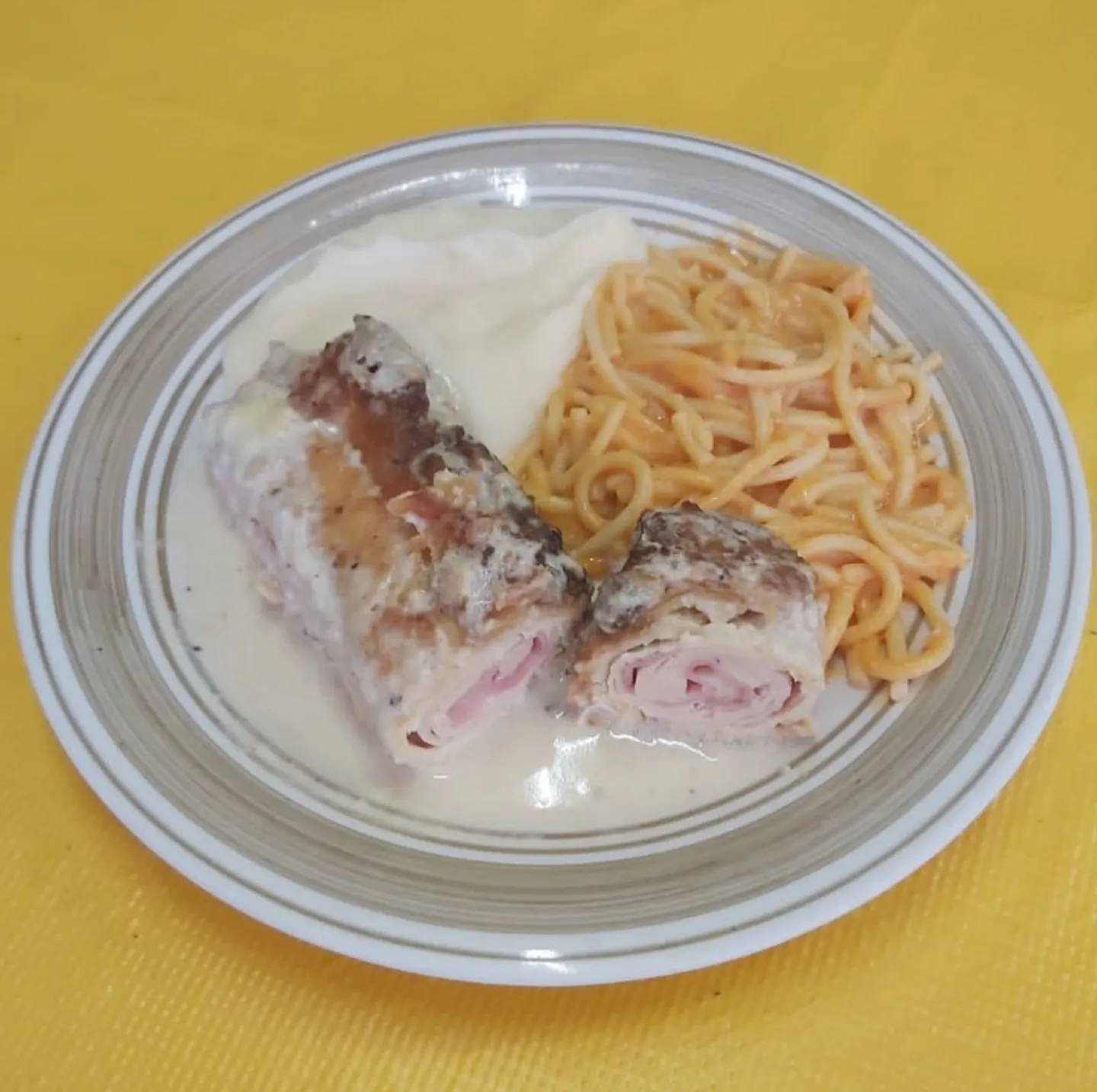 Pechuga rellena de jamón y queso en salsa blanca con puré y espagueti rojo